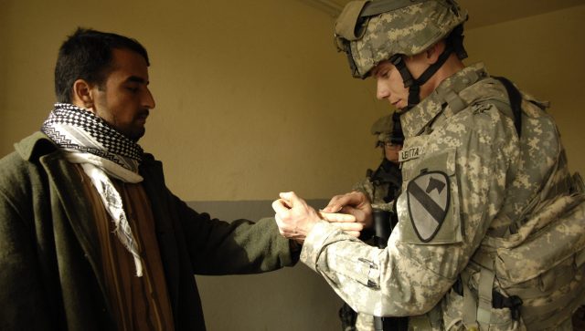 U.S. Army Sgt. Rosario Leotta, 2nd Battalion, 7th Cavalry Regiment, 4th Brigade Combat Team, 1st Cavalry Division, tests an Iraqi man's hands for explosive residue during a search for improvised explosive device makers at a propane distributing station i n Kirkush, Iraq, Feb. 7, 2007. (U.S. Air Force photo by Staff Sgt. JoAnn S. Makinano) (Released)