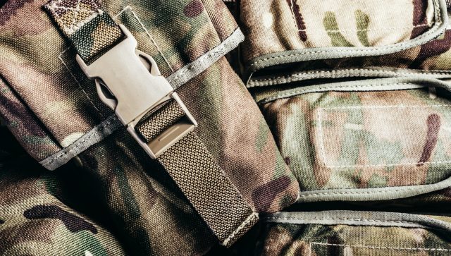 Close-up photo of multi camouflaged soldier vest pouches with lock catch..